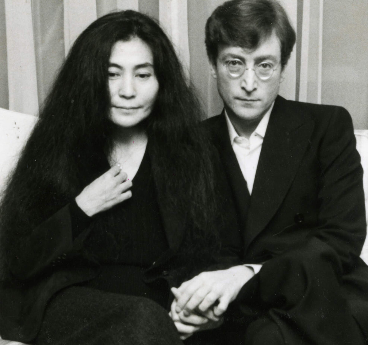 Black-and-white portrait of Yoko Ono and John Lennon seated together