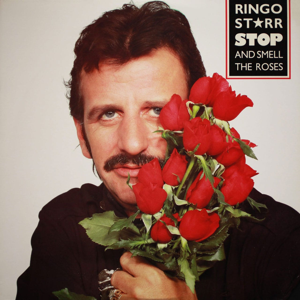 Ringo Starr holding red roses on the cover of Stop and Smell the Roses