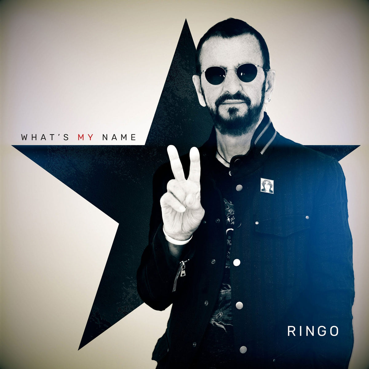 Ringo Starr’s What’s My Name album cover, showing Ringo making a peace sign in front of a large star